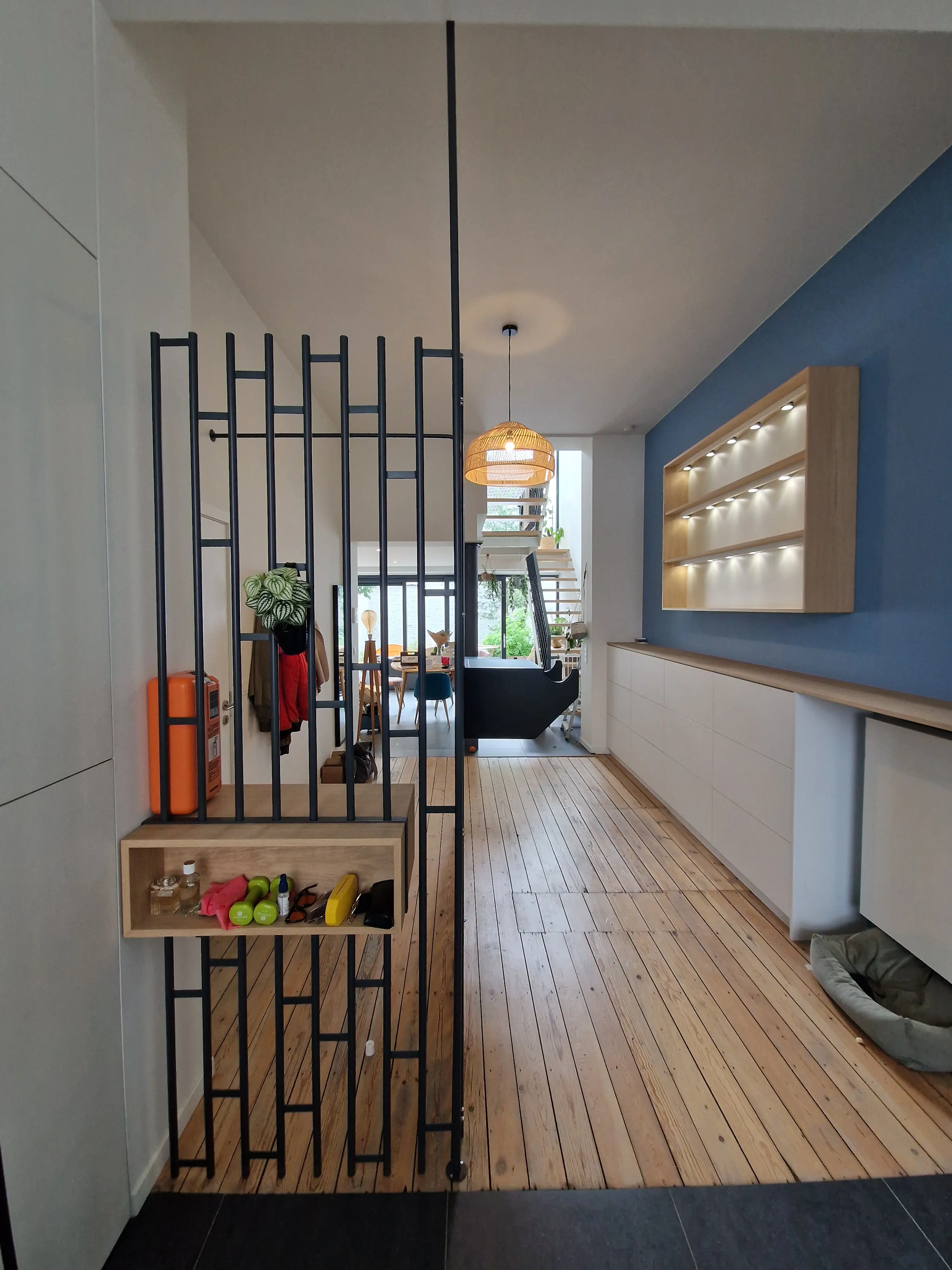 Hall d'entrée conceptuel avec claustra métallique anthracite et rangement chaussures